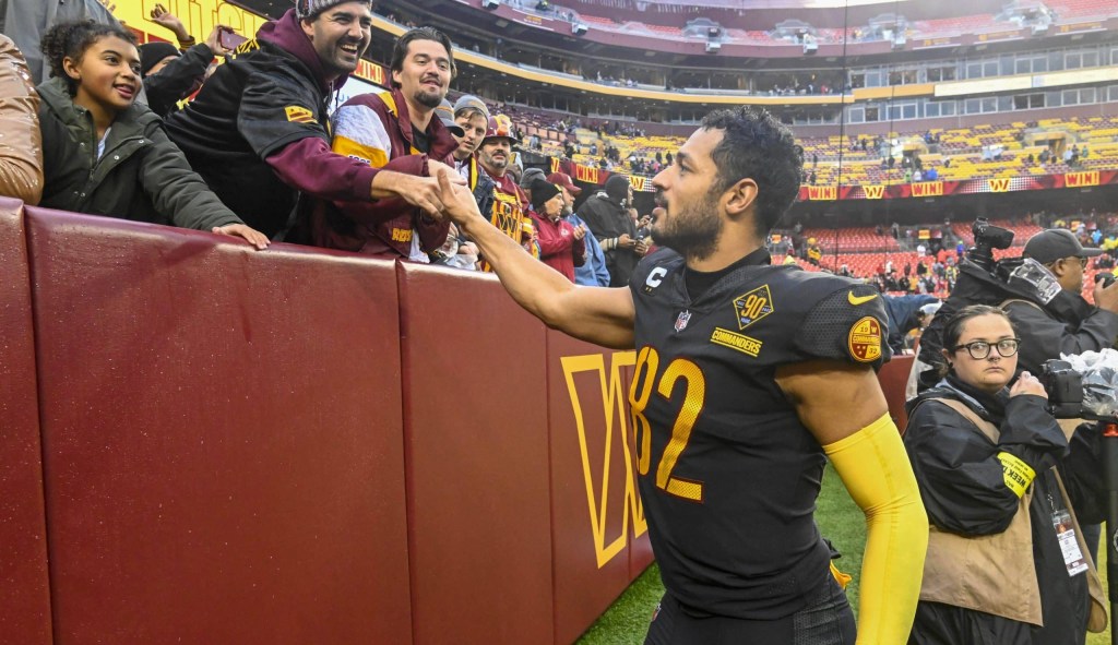 Commanders tight end Logan Thomas (82) celebrates with fans after a game.