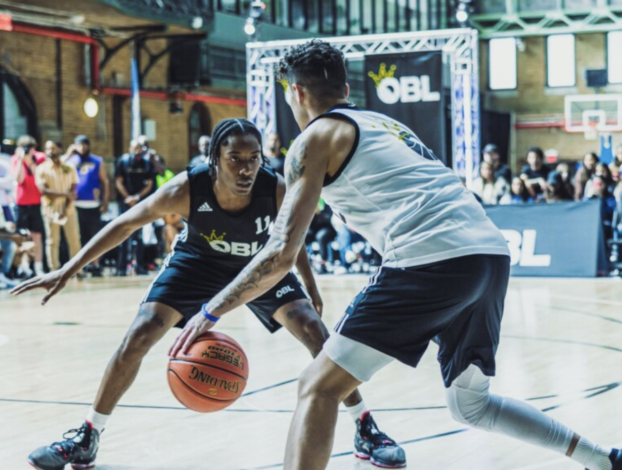 Two basketball players compete in the Ones Basketball League.