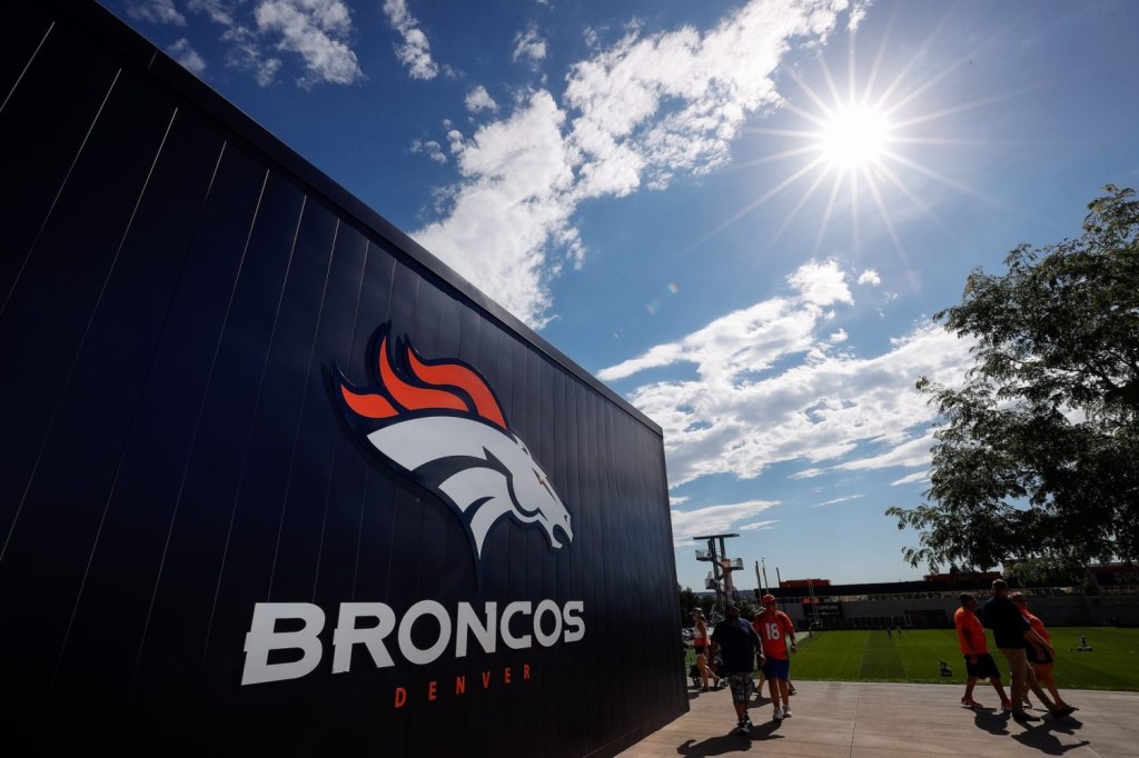A view of a Denver Broncos logo on a building at the team's training camp.