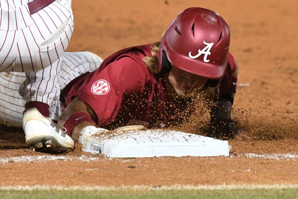 Alabama hitter Jim Jarvis dives back into first safely on a pickoff play against Troy at Sewell-Thomas Stadium in Tuscaloosa, Ala., Saturday June 4, 2023, in the winners bracket game of the NCAA Regional Baseball Tournament.