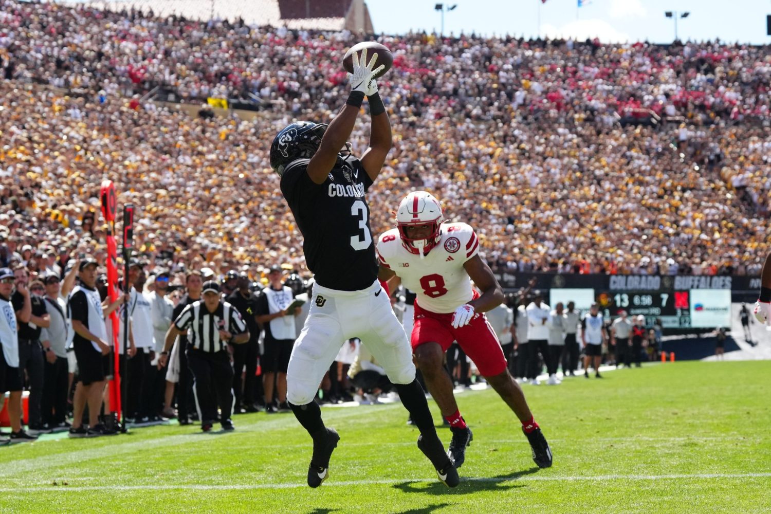 Colorado Buffaloes running back Dylan Edwards reaches for the ball past Nebraska Cornhuskers cornerback Deshon Singleton in the third quarter at Folsom Field.