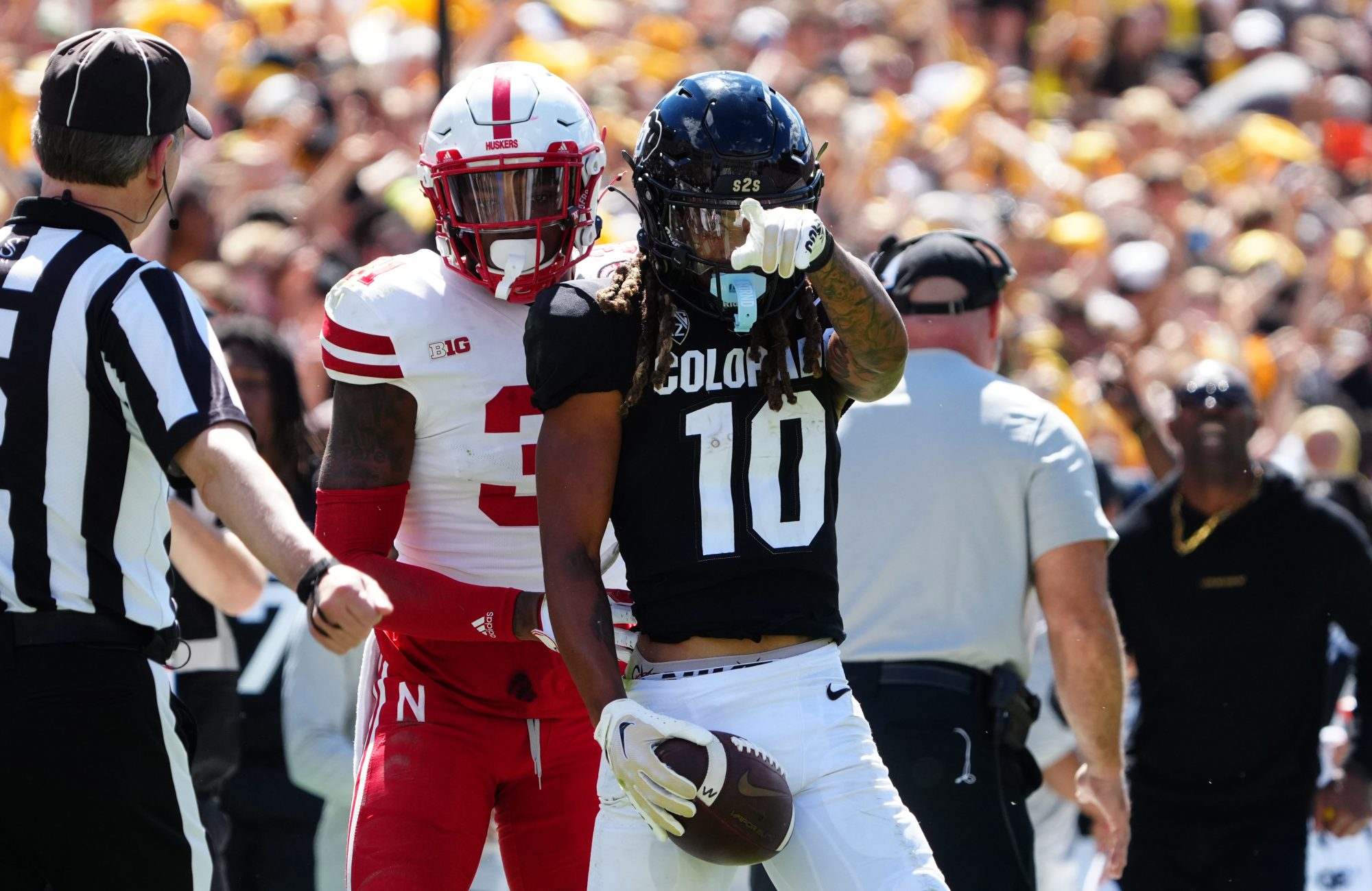 Colorado Buffaloes wide receiver Xavier Weaver (10) reacts to his first down reception catch next to Nebraska Cornhuskers linebacker Nick Henrich (3) during the third quarter at Folsom Field.