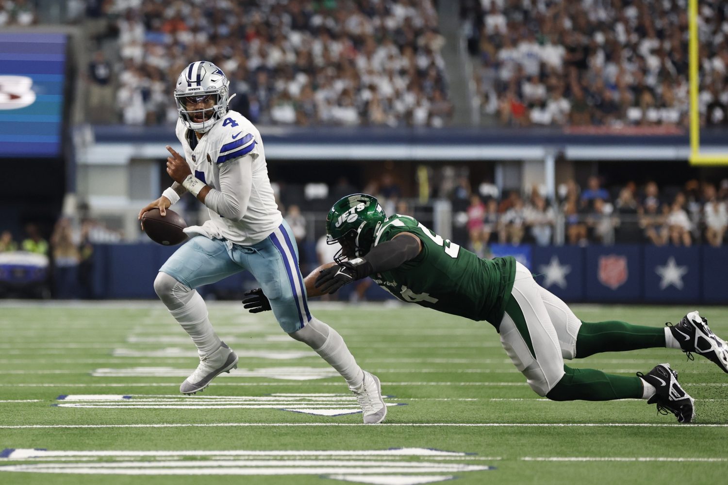 Dallas Cowboys quarterback Dak Prescott is tripped up by New York Jets defensive end Solomon Thomas in the second quarter at AT&T Stadium.