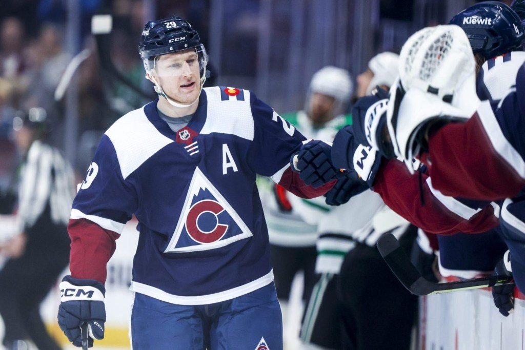 Colorado Avalanche center Nathan MacKinnon celebrates with the bench after scoring a goal against the Dallas Stars in the first period at Ball Arena.