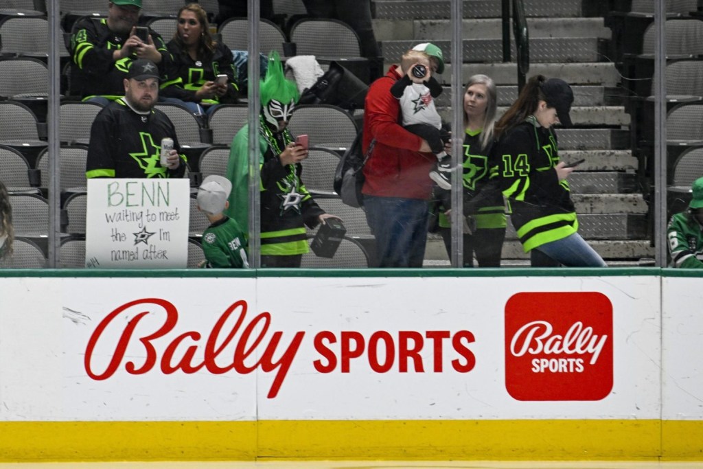 A view of the Bally Sports logo and a Dallas Stars fan with a sign for left wing Jamie Benn before the game between the Dallas and the Vegas Golden Knights at the American Airlines Center.