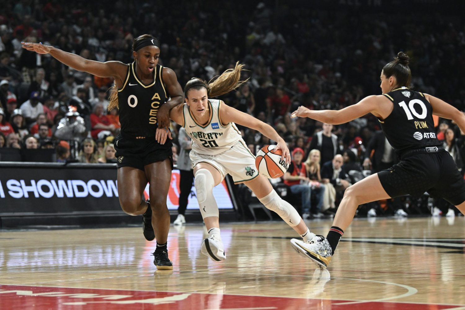 New York Liberty guard Sabrina Ionescu drives past Las Vegas Aces guard Jackie Young and guard Kelsey Plum in the first half during game one of the 2023 WNBA Finals at Michelob Ultra Arena.
