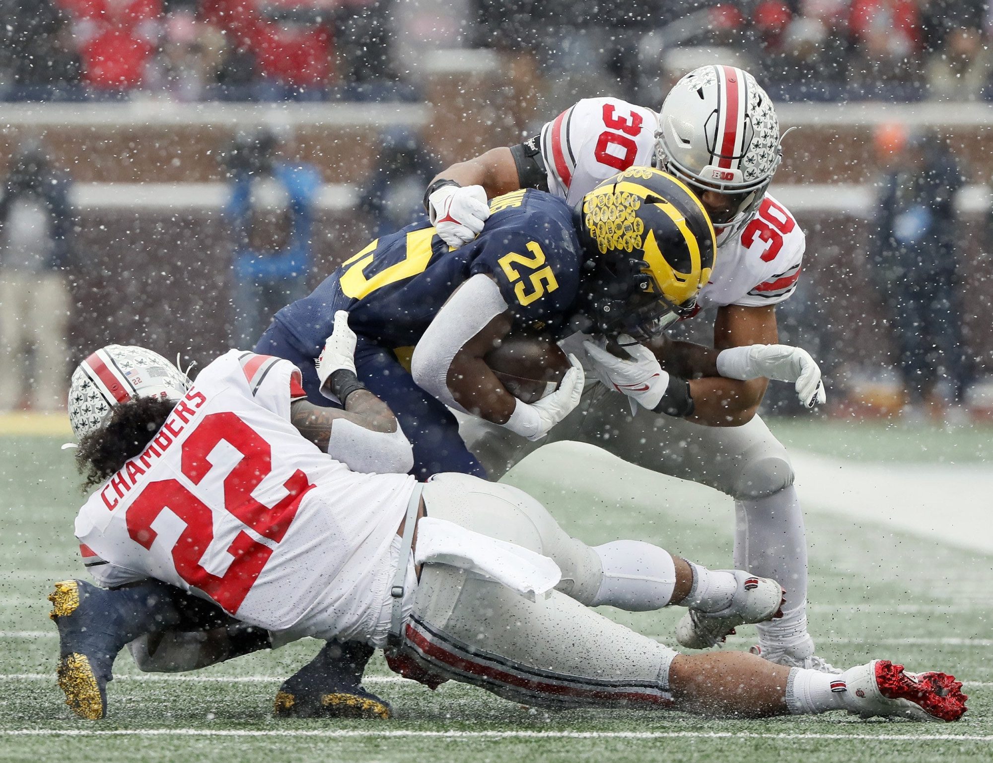 Ohio State Buckeyes linebacker Steele Chambers and Ohio State Buckeyes linebacker Cody Simon tackle Michigan Wolverines running back Hassan Haskins during the first quarter of their NCAA College football at Michigan Stadium in Ann Arbor, MI on November 27, 2021.