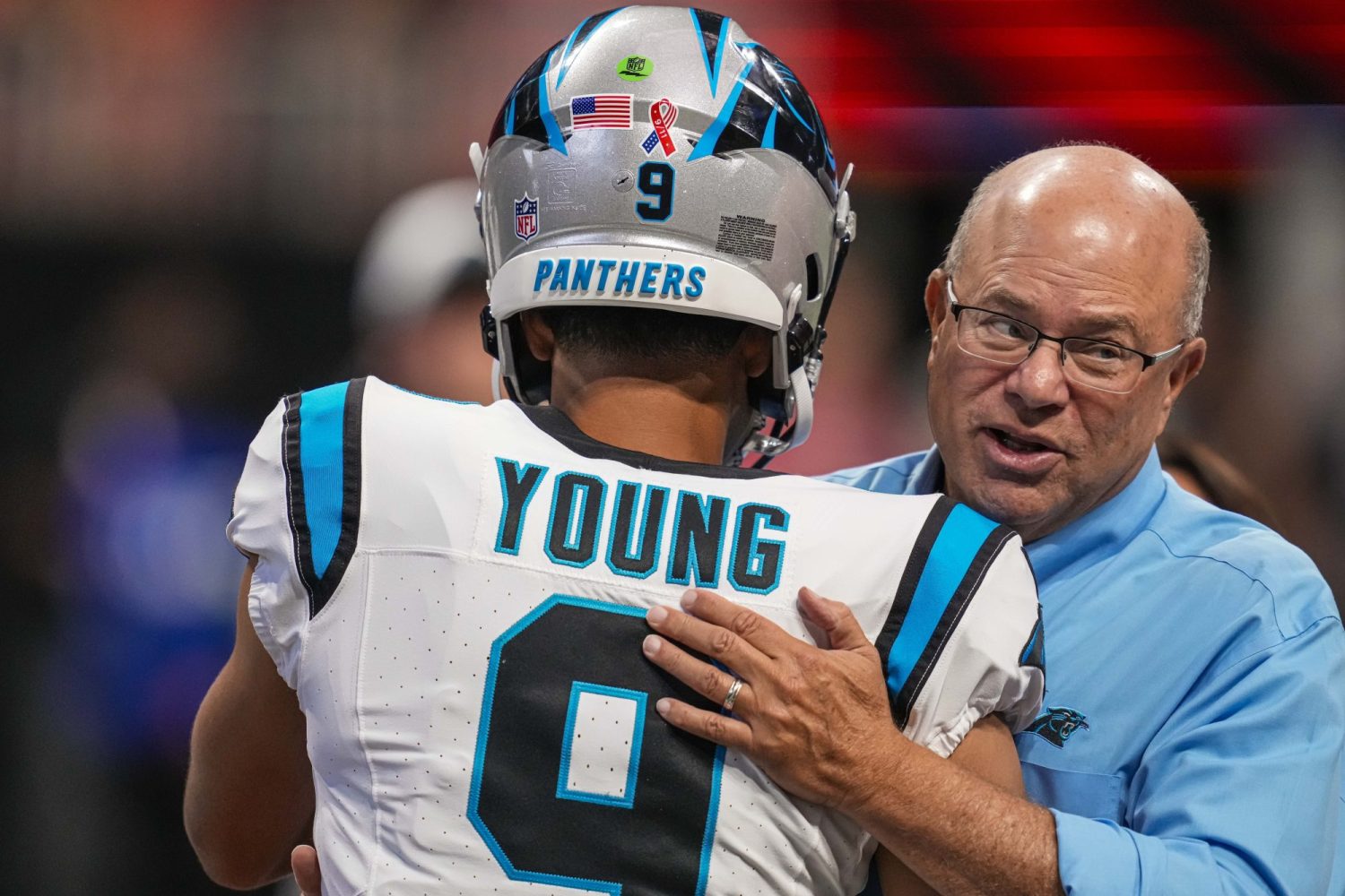 Carolina Panthers quarterback Bryce Young hugs team owner David Tepper on the field prior to the game against the Atlanta Falcons at Mercedes-Benz Stadium.