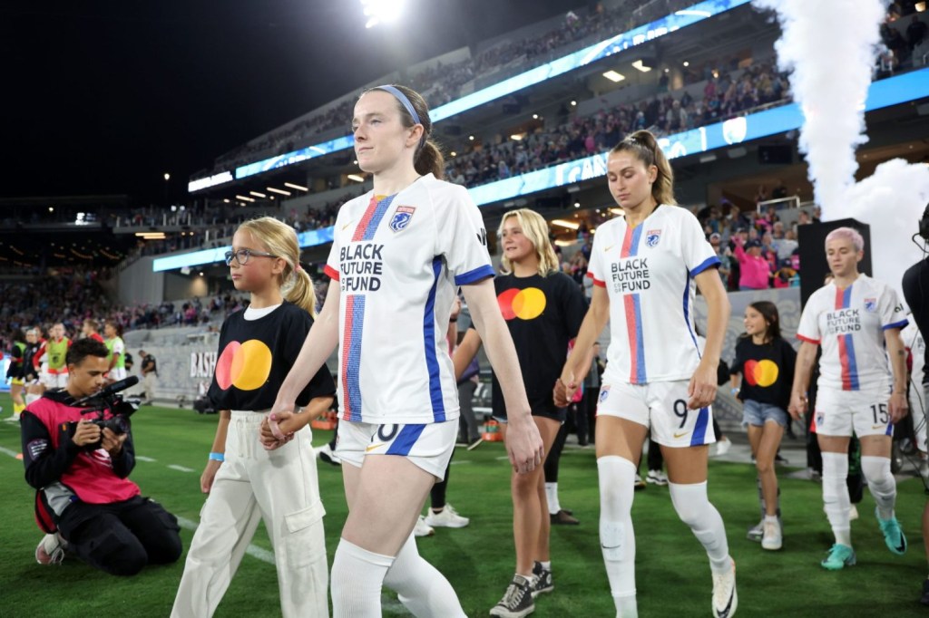 OL Reign midfielder Rose Lavelle is escorted onto the field before the game against the San Diego Wave FC at Snapdragon Stadium.