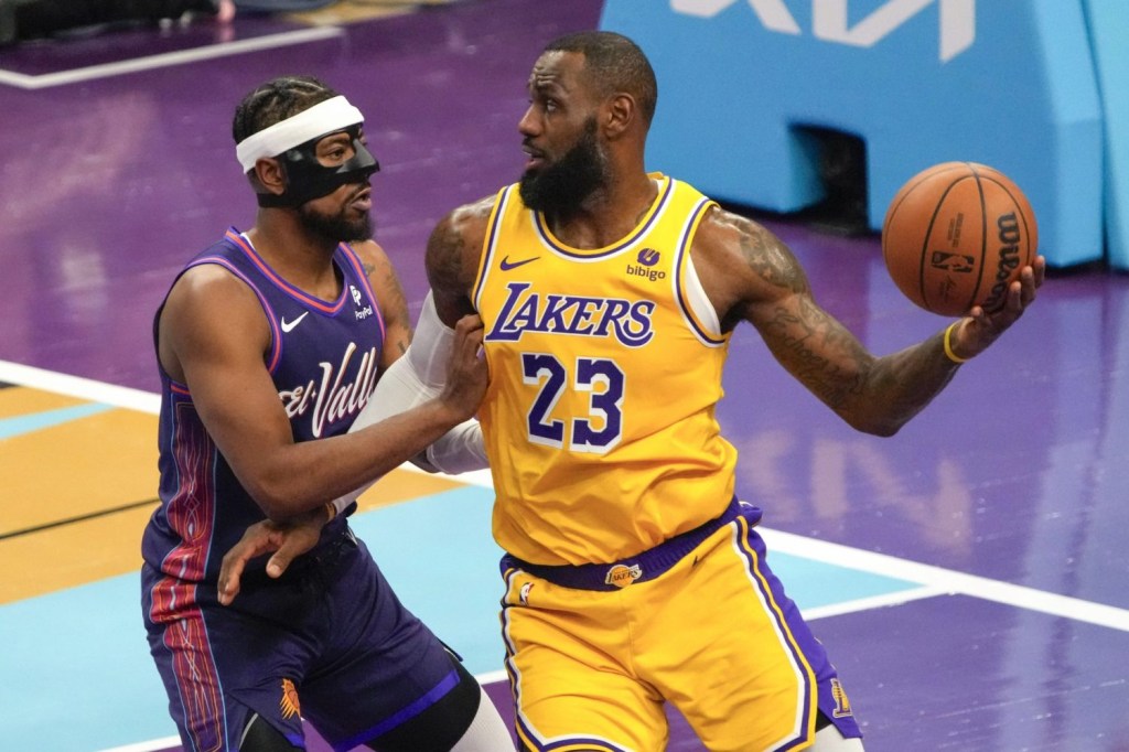 Los Angeles Lakers forward LeBron James drives against Phoenix Suns guard Jordan Goodwin in the first half at Footprint Center.