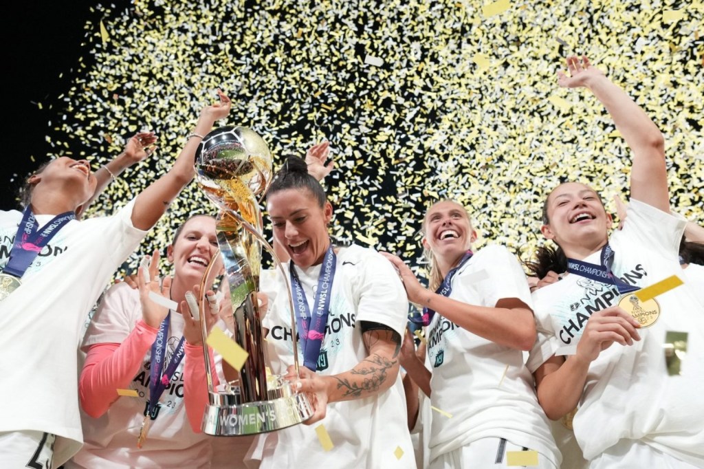 New Jersey/New York Gotham FC defender Ali Krieger hoists the trophy with her teammates after defeating the OL Reign in the NWSL Championship at Snapdragon Stadium.