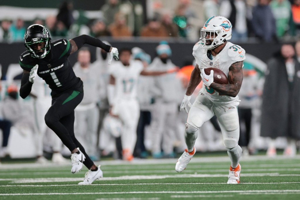 Miami Dolphins running back Raheem Mostert runs with the ball against New York Jets cornerback Sauce Gardner during the second half at MetLife Stadium.