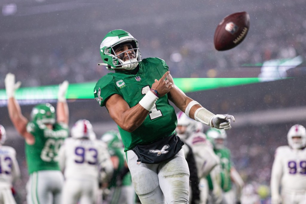 Philadelphia Eagles quarterback Jalen Hurts tosses the ball to fans after scoring a touchdown against the Buffalo Bills during the first quarter at Lincoln Financial Field.