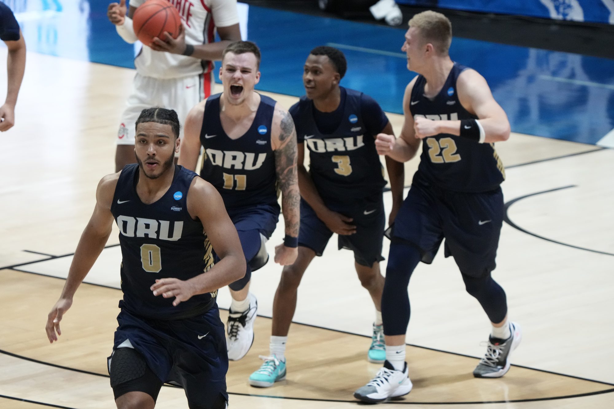 Mar 19, 2021; West Lafayette, Indiana, USA; Oral Roberts Golden Eagles forward Kevin Obanor (0) and guard Carlos Jurgens (11) and guard Max Abmas (3) and forward Francis Lacis (22) celebrate after an overtime victory over the Ohio State Buckeyes in the first round of the 2021 NCAA Tournament at Mackey Arena.