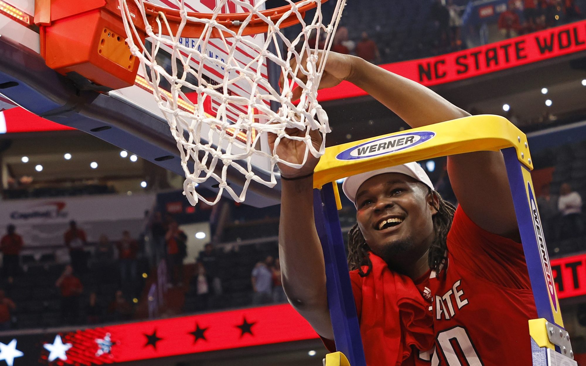 Mar 16, 2024; Washington, D.C., USA; North Carolina State Wolfpack forward DJ Burns Jr. (30) cuts the net after defeating the North Carolina Tar Heels for the ACC Conference Championship at Capital One Arena.