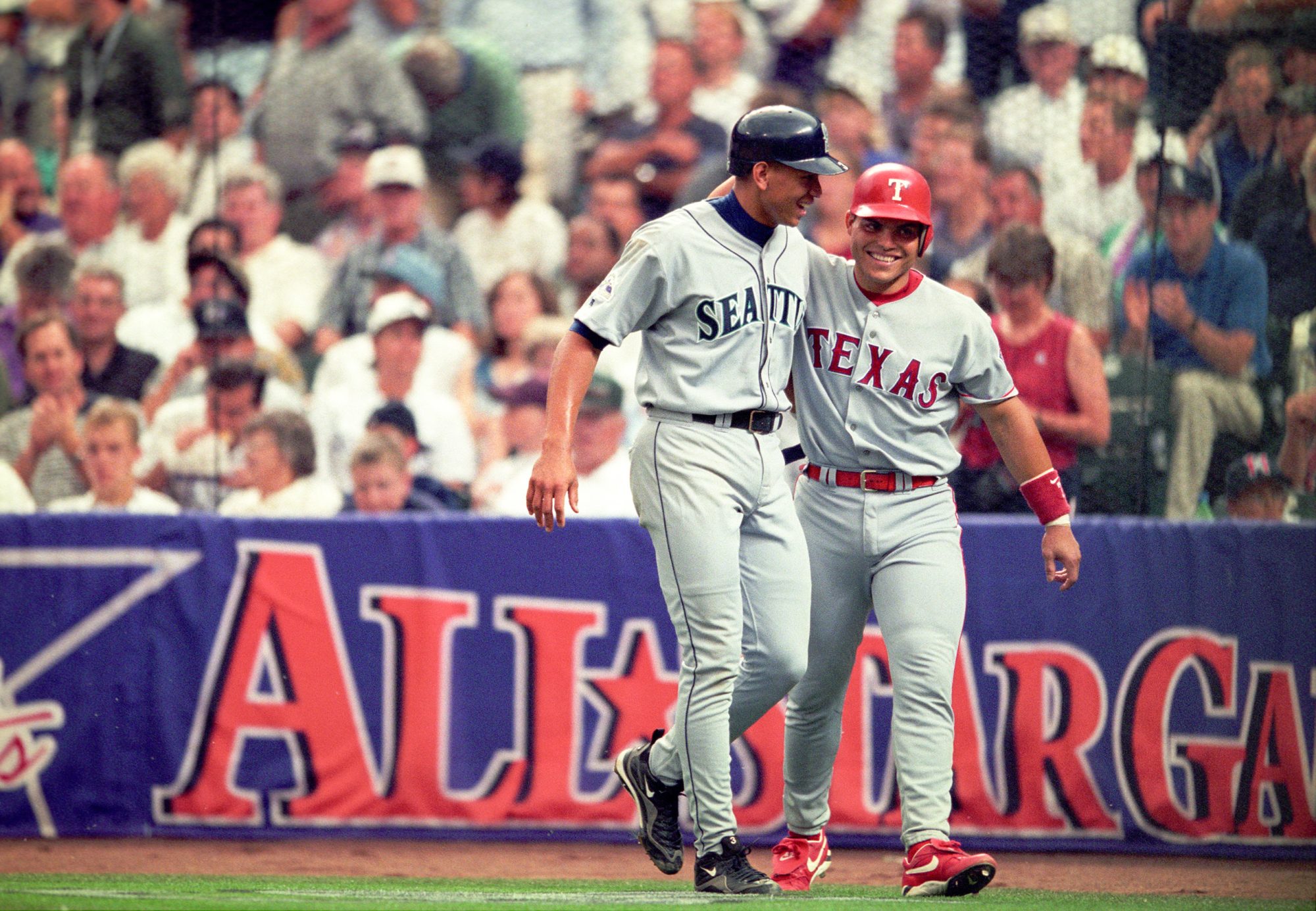 Jul 7, 1998; Denver, CO, USA; FILE PHOTO; American League shortstop Alex Rodriguez (3) of the Seattle Mariners reacts with catcher Ivan Rodriguez (7) of the Texas Rangers against the National League during the 1998 MLB All-Star Game at Coors Field. Mandatory Credit: V.J. Lovero-USA TODAY NETWORK