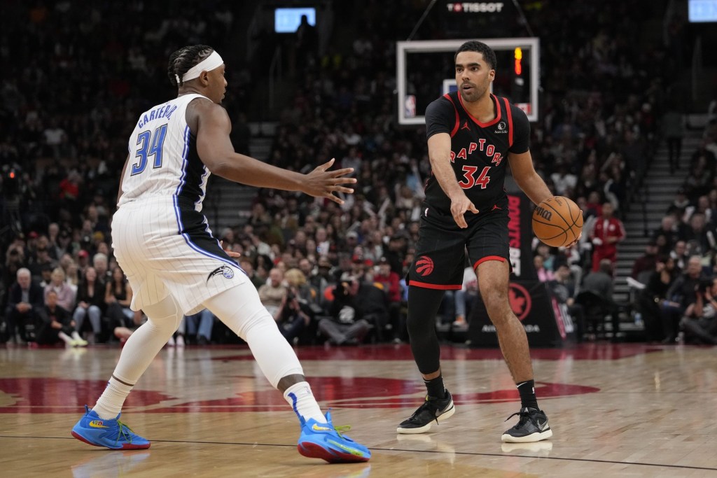 Mar 15, 2024; Toronto, Ontario, CAN; Toronto Raptors forward Jontay Porter (34) points to a spot as he controls the ball against Orlando Magic center Wendell Carter Jr. (34) during the second half at Scotiabank Arena.