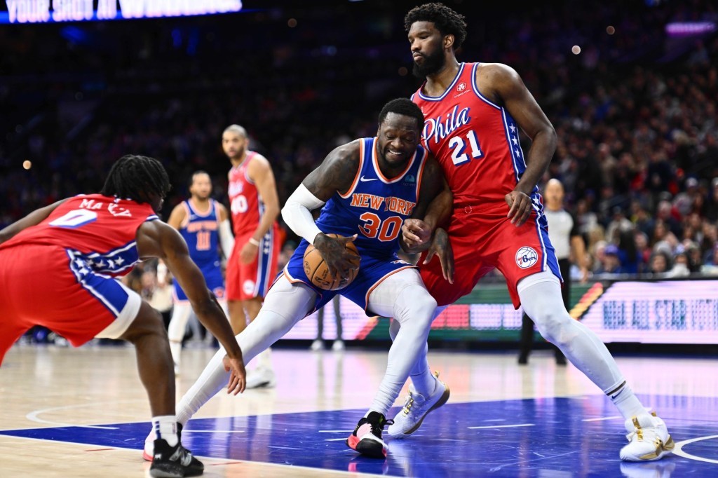 Jan 5, 2024; Philadelphia, Pennsylvania, USA; New York Knicks forward Julius Randle (30) drives against Philadelphia 76ers center Joel Embiid (21) in the first quarter at Wells Fargo Center.