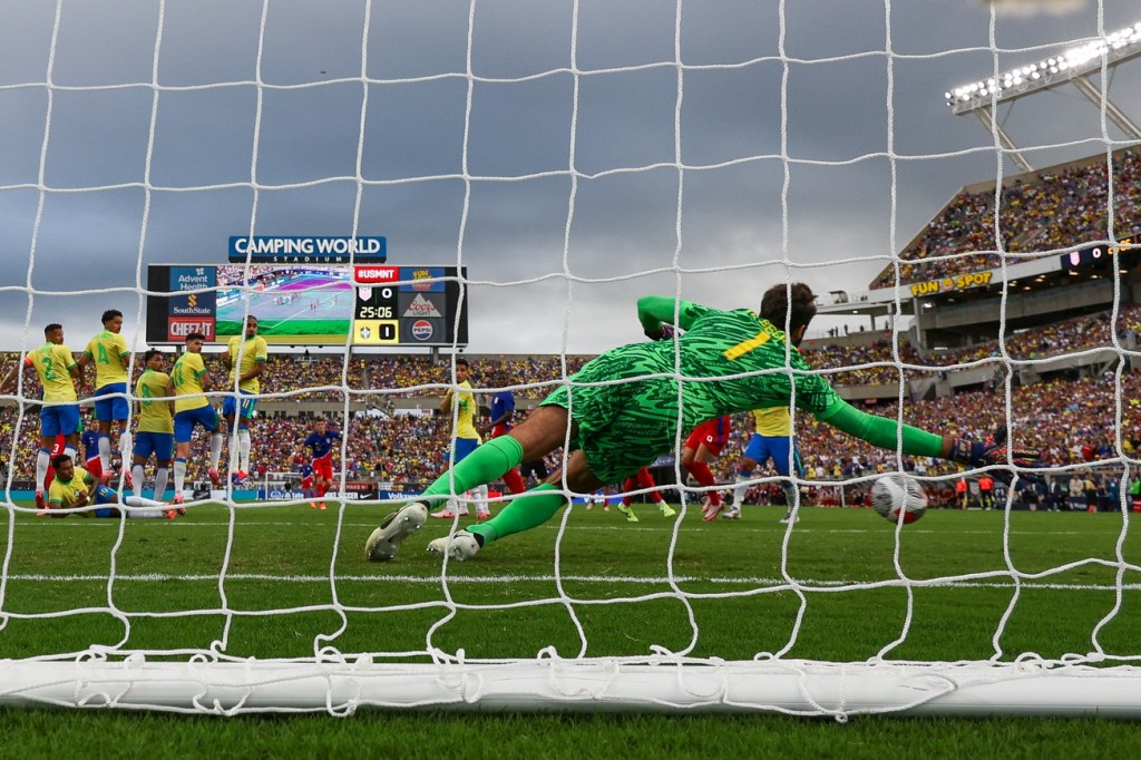 Jun 12, 2024; Orlando, Florida, USA; United States midfielder Christian Pulisic (10) scores a goal past Brazil goalkeeper Alisson Becker (1) in the first half during the Continental Clasico at Camping World Stadium.