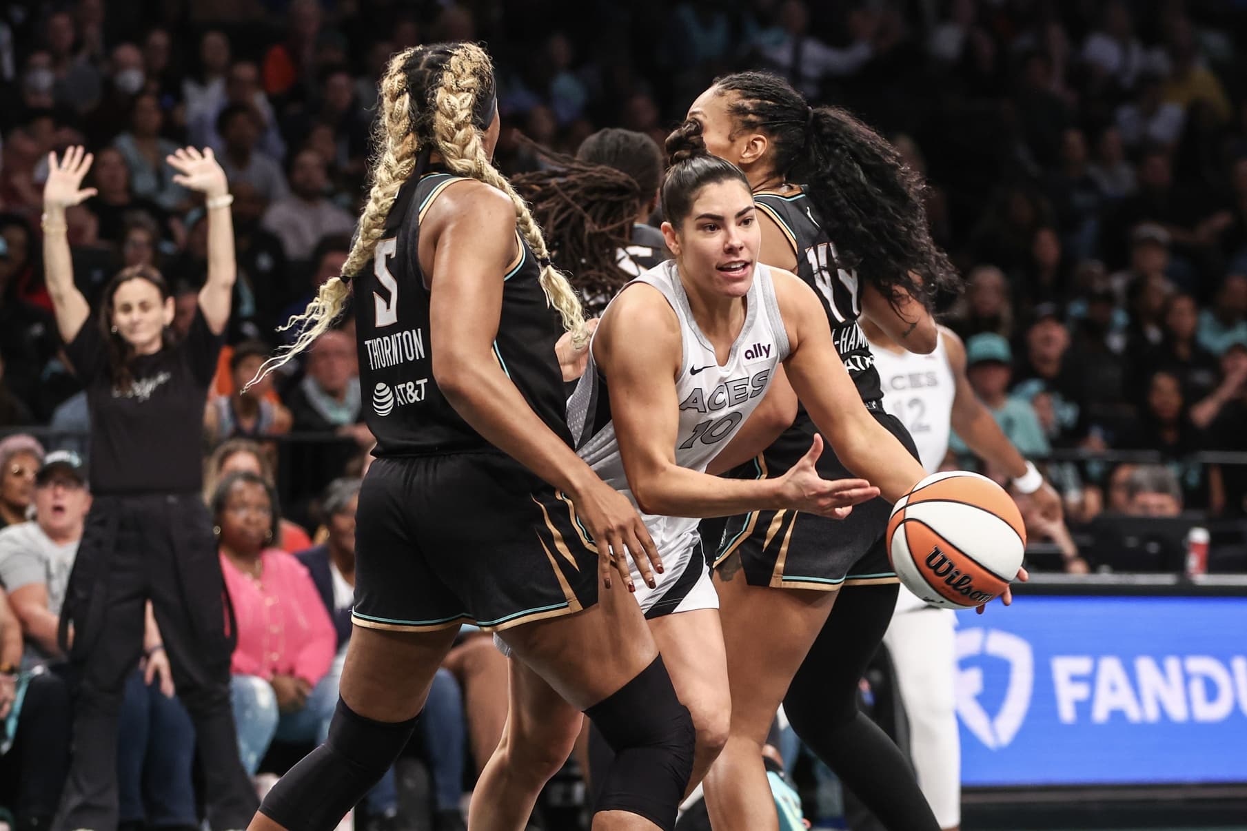 Oct 1, 2024; Brooklyn, New York, USA; Las Vegas Aces guard Kelsey Plum (10) drives past New York Liberty forwards Kayla Thornton (5) and Betnijah Laney-Hamilton (44) during game two of the 2024 WNBA Semi-finals at Barclays Center.