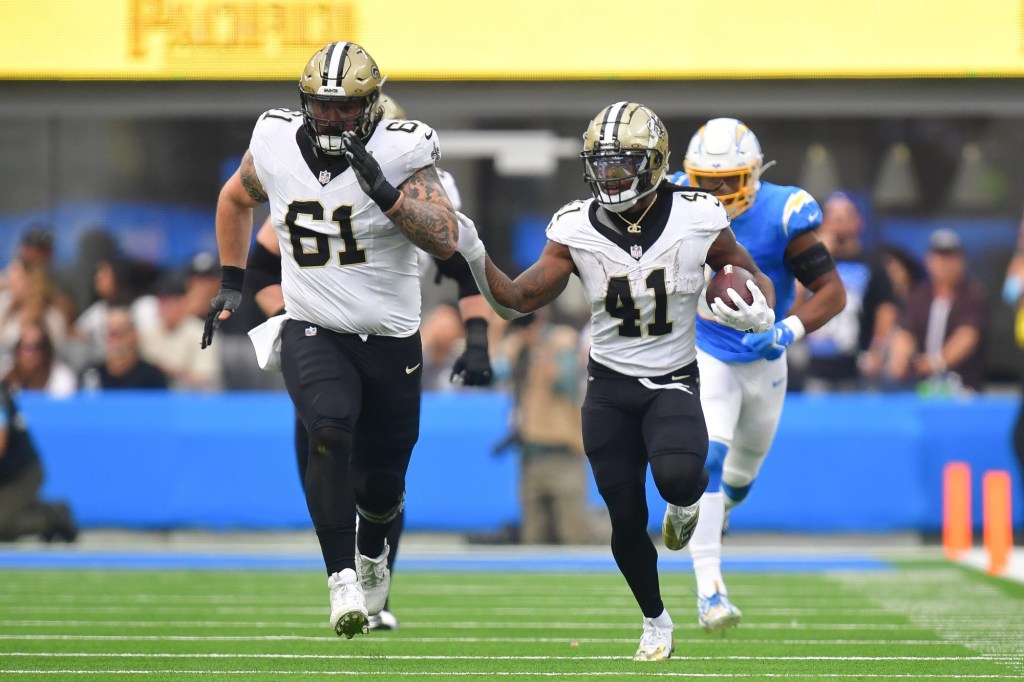 Oct 27, 2024; Inglewood, California, USA; New Orleans Saints running back Alvin Kamara (41) runs the ball as center Connor McGovern (61) provides coverage against the Los Angeles Chargers during the first half at SoFi Stadium.