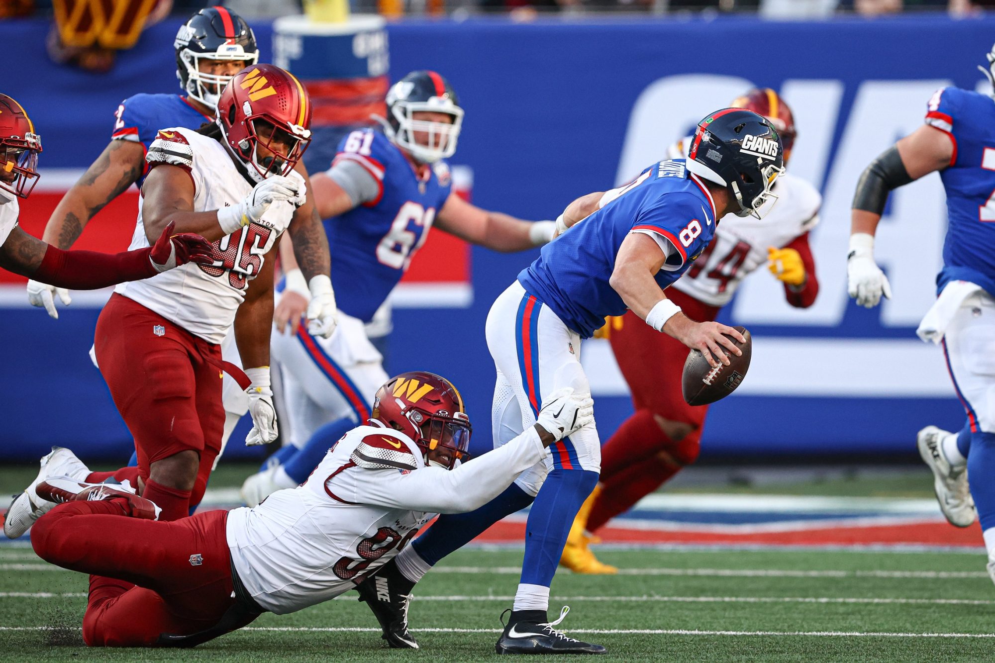 Nov 3, 2024; East Rutherford, New Jersey, USA; New York Giants quarterback Daniel Jones (8) is sacked during an extra point attempt by Washington Commanders defensive end Dorance Armstrong (92) during the second half at MetLife Stadium.