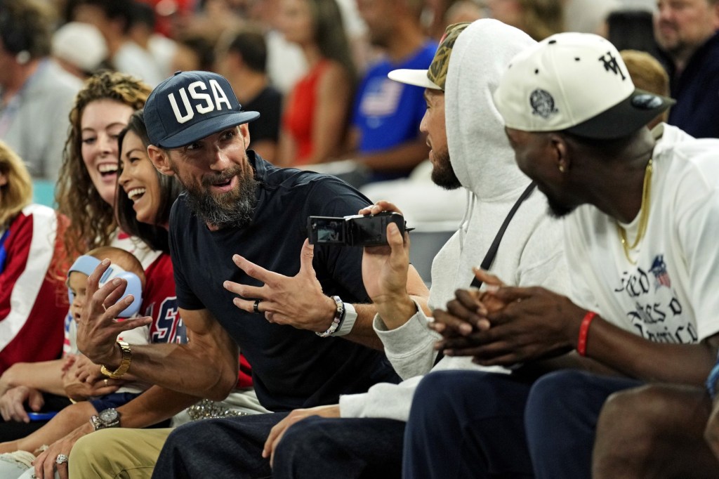 Aug 7, 2024; Paris, France; Michaels Phelps laughs with USA basketball player Devon Booker during the game between the United States and Nigeria in the women’s basketball quarterfinals during the Paris 2024 Olympic Summer Games at Accor Arena.