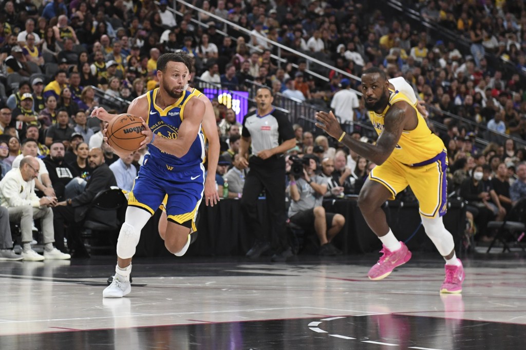 Oct 15, 2024; Las Vegas, Nevada, USA; Golden State Warriors guard Stephen Curry (30) drives past Los Angeles Lakers forward LeBron James (23) in the second quarter during a preseason game at T-Mobile Arena.