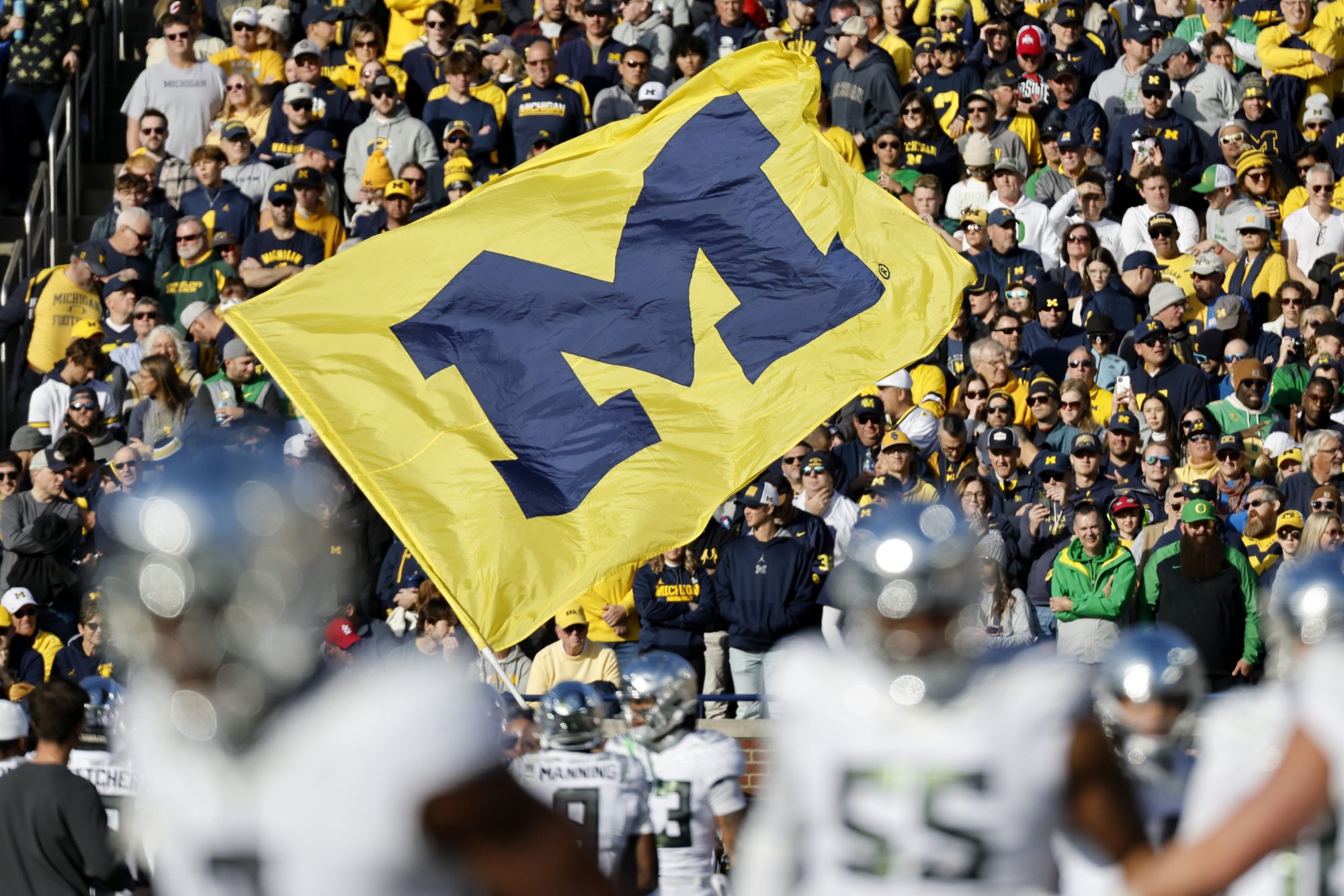 Nov 2, 2024; Ann Arbor, Michigan, USA; Michigan Wolverines cheerleader runs with a flag before the game against the Oregon Ducks at Michigan Stadium.