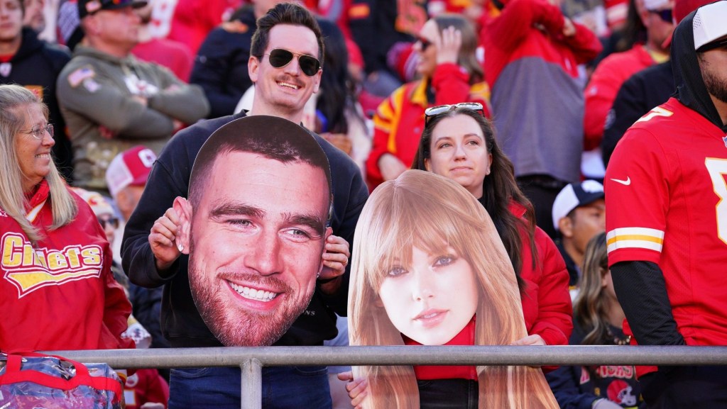 Nov 10, 2024; Kansas City, Missouri, USA; Kansas City Chiefs fans hold fathead signs of Travis Kelce (not pictured) and Taylor Swift during the second half of the game against the Denver Broncos at GEHA Field at Arrowhead Stadium