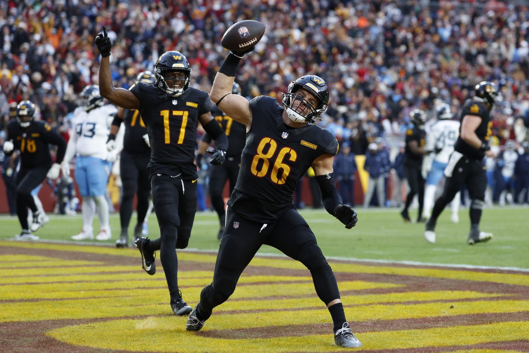 Dec 1, 2024; Landover, Maryland, USA; Washington Commanders tight end Zach Ertz (86) spikes the ball in the end zone after catching a touchdown pass as Commanders wide receiver Terry McLaurin (17) celebrates against the Tennessee Titans during the fourth quarter at Northwest Stadium.