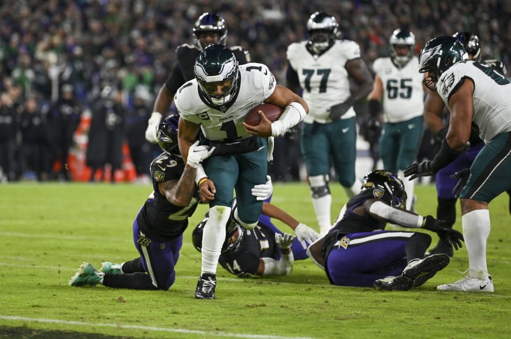 Dec 1, 2024; Baltimore, Maryland, USA; Baltimore Ravens safety Ar'Darius Washington (29) tackles Philadelphia Eagles quarterback Jalen Hurts (1) on the one yard line during the first half at M&T Bank Stadium.