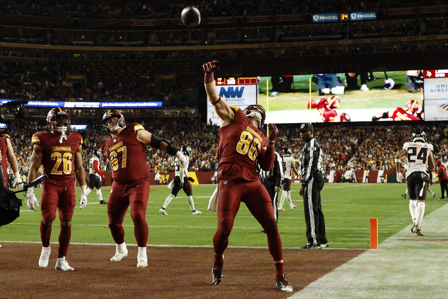 Dec 29, 2024; Landover, Maryland, USA; Washington Commanders tight end Zach Ertz (86) celebrates by throwing the ball into the stands after catching a touchdown pass against the Atlanta Falcons during the third quarter at Northwest Stadium.