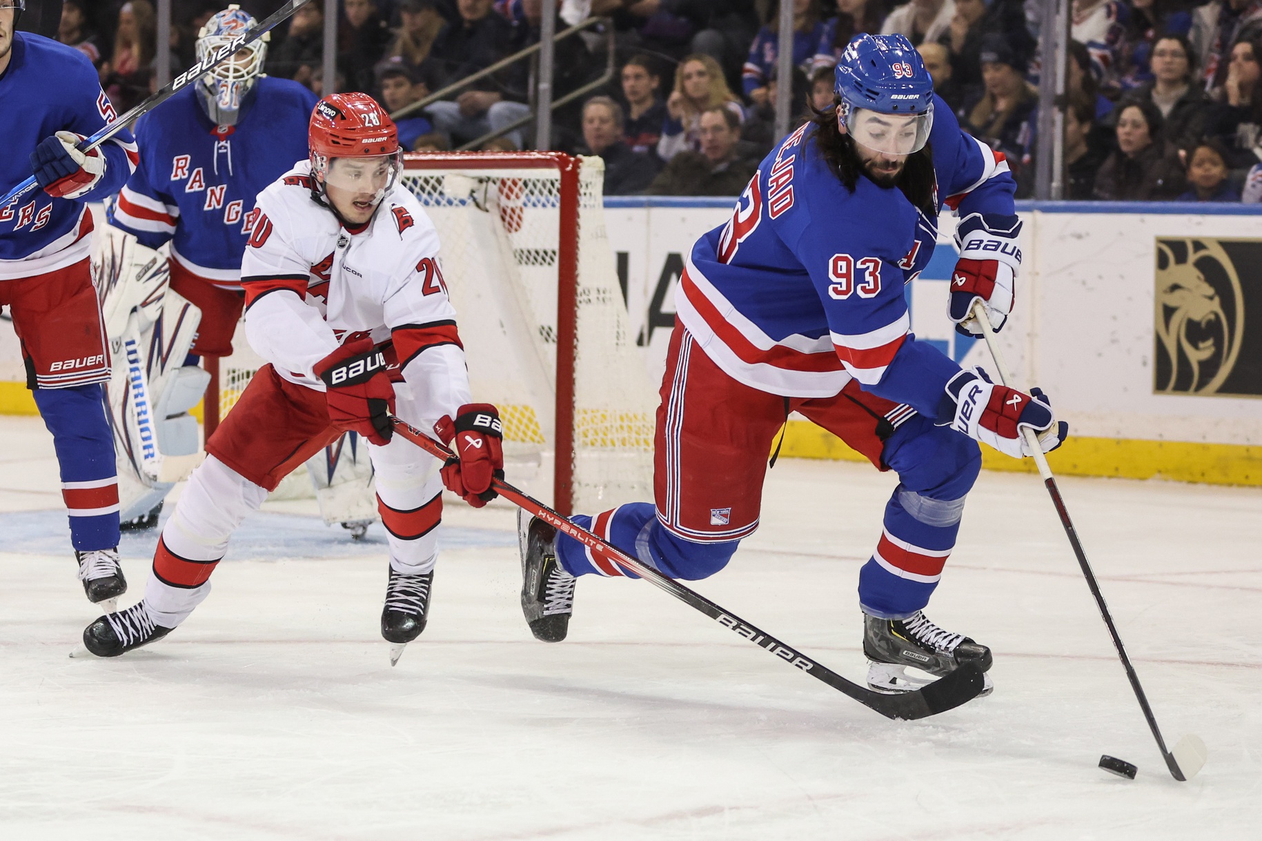 Dec 22, 2024; New York, New York, USA; Carolina Hurricanes center Sebastian Aho (20) and New York Rangers center Mika Zibanejad (93) chase the puck in the second period at Madison Square Garden.