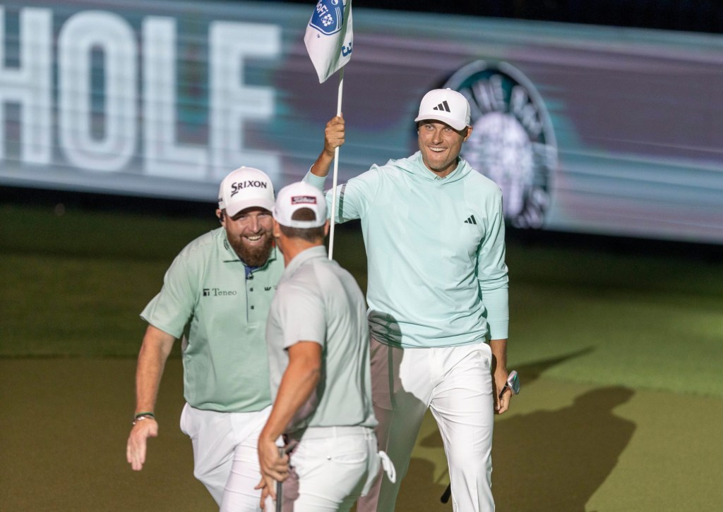 Bay Club golfer Shane Lowry, left, celebrates a putt with Wyndham Clark and Ludvig Aberg, right, during a golf match against the New York Gulf Club at SoFi Center, the home of TGL, the interactive golf league founded by Tiger Woods and Rory McIlroy on January 7, 2025 in Palm Beach Gardens, Florida.