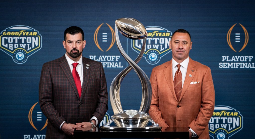 Ohio State Buckeyes Head Coach Ryan Day, left, and Texas Longhorns Head Coach Steve Sarkisian stand next to the trophy for a photo following the Coaches' Press Conference at AT&T Stadium, Jan. 9, 2024. Both coaches answered questions from the media during the conference, and will face each other in the Cotton Bowl College Football Playoff semi-final game on Friday.