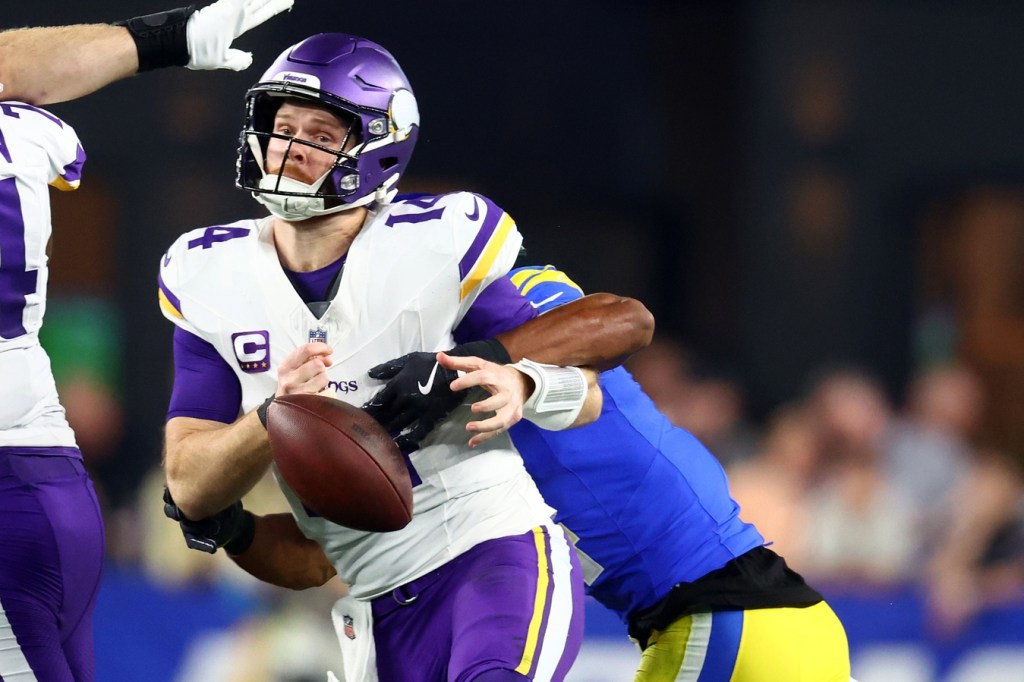 Jan 13, 2025; Glendale, AZ, USA; Minnesota Vikings quarterback Sam Darnold (14) is sacked by Los Angeles Rams cornerback Ahkello Witherspoon (4) during the first half in an NFC wild card game at State Farm Stadium.