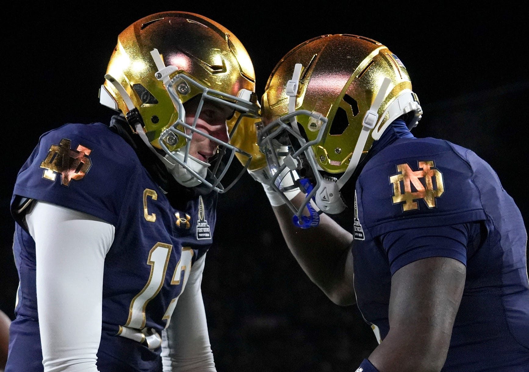 Notre Dame Fighting Irish quarterback Riley Leonard and running back Jeremiah Love celebrate a touchdown during the first half of a game against the Indiana Hoosiers in the first round of the College Football Playoff.