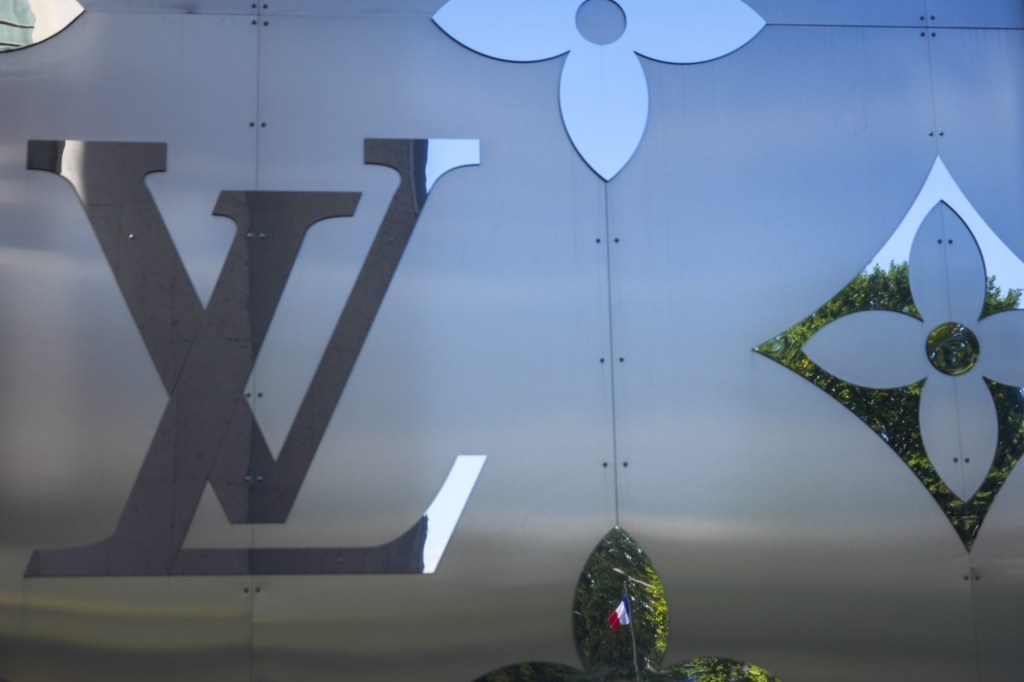 Jul 13, 2024; Paris, France; A detail view of a French flag reflected in the decorative siding of the Louis Vuitton store ahead of the 2024 Paris Olympics