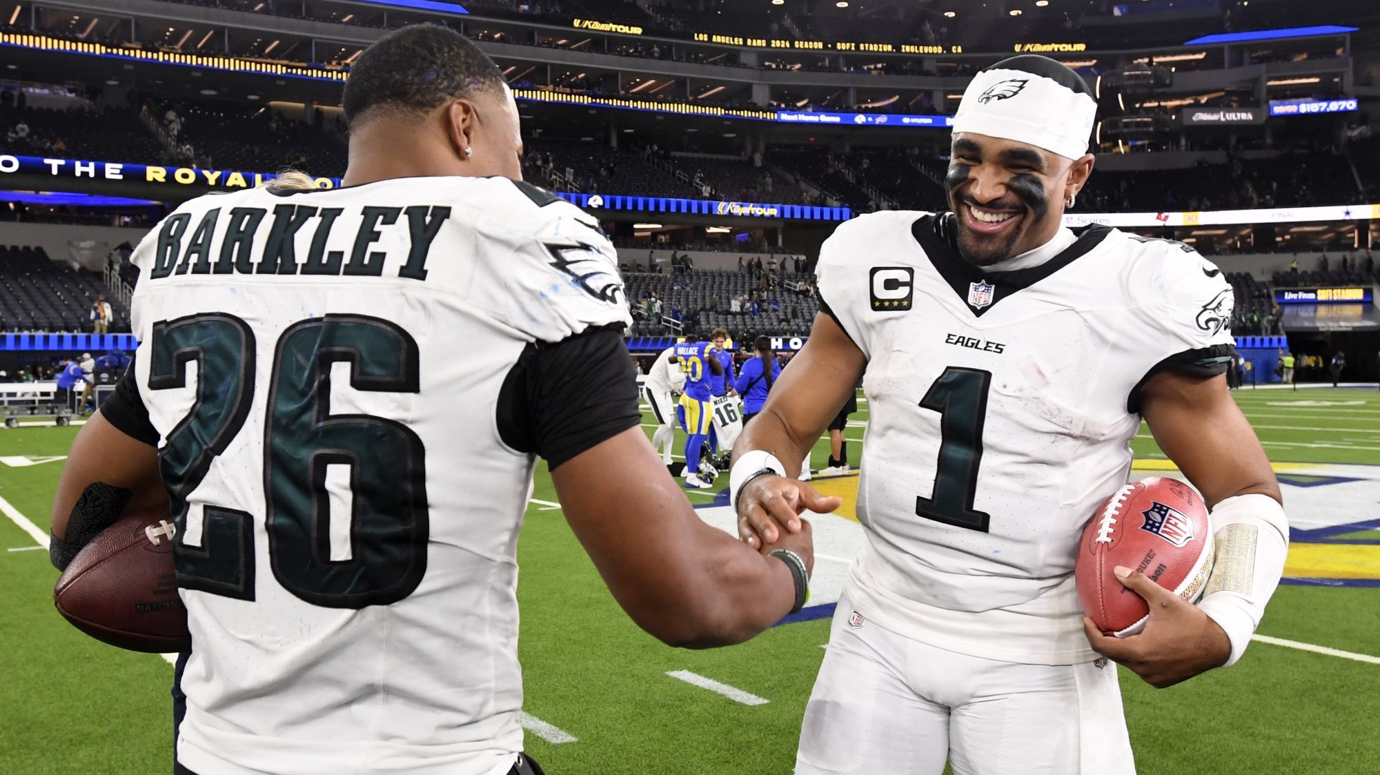 Nov 24, 2024; Inglewood, California, USA; Philadelphia Eagles quarterback Jalen Hurts (1) celebrates with running back Saquon Barkley (26) after the Eagles defeat the Los Angeles Rams during the first half at SoFi Stadium.