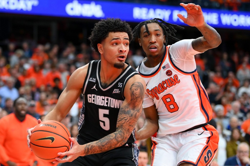 Dec 14, 2024; Syracuse, New York, USA; Georgetown Hoyas guard Micah Peavy (5) drives against Syracuse Orange guard Elijah Moore (8) during the first half at the JMA Wireless Dome.