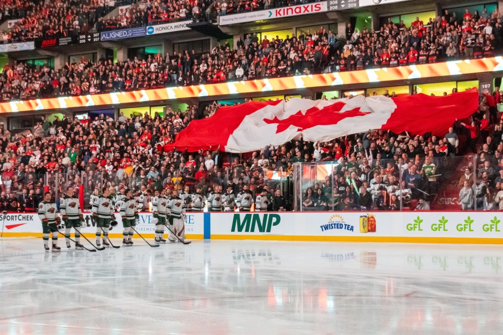 Feb 1, 2025; Ottawa, Ontario, CAN; The Canadian flag is passed along during the National Anthem prior to start of game between the Minnesota Wild and the Ottawa Senators at the Canadian Tire Centre.