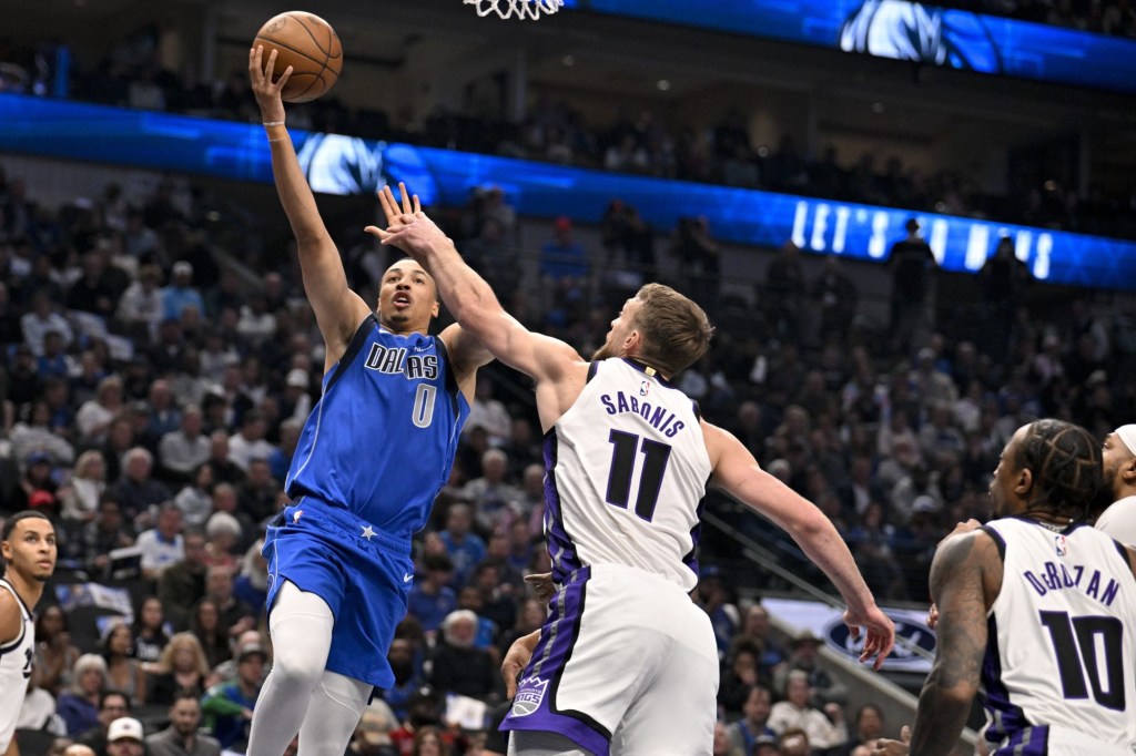 Feb 10, 2025; Dallas, Texas, USA; Dallas Mavericks guard Dante Exum (0) shoots over Sacramento Kings forward Domantas Sabonis (11) during the first quarter at the American Airlines Center.