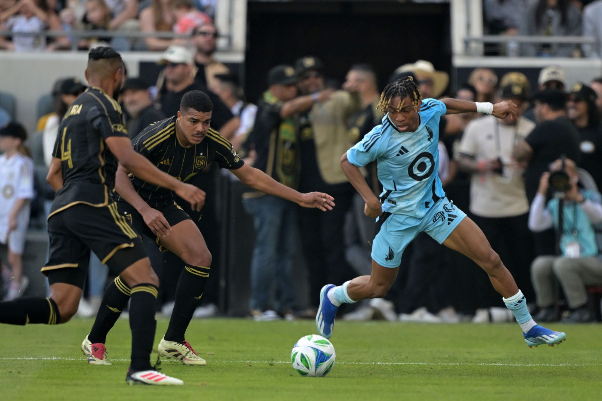 Feb 22, 2025; Los Angeles, California, USA; Minnesota United defender Loic Mesanvi (90) kicks the ball against LAFC during the second half at BMO Stadium.