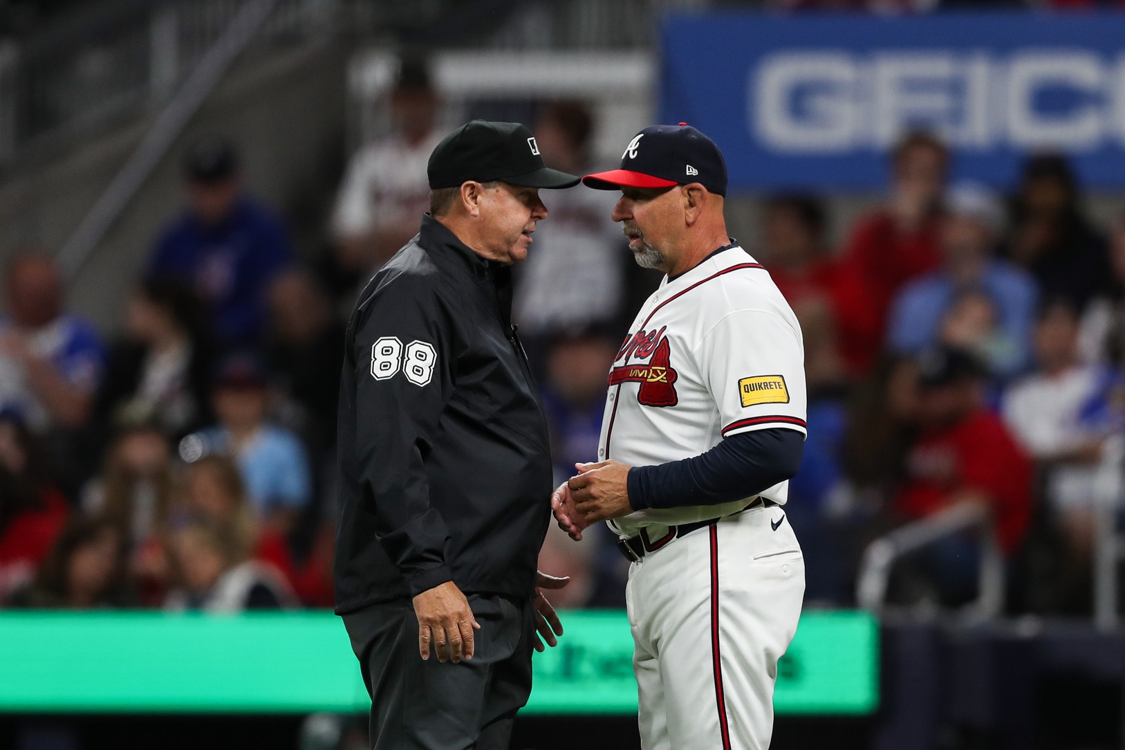 Atlanta Braves general manager Walt Weiss talks with umpire against the Kansas City Royals in the fourth inning at Truist Park.