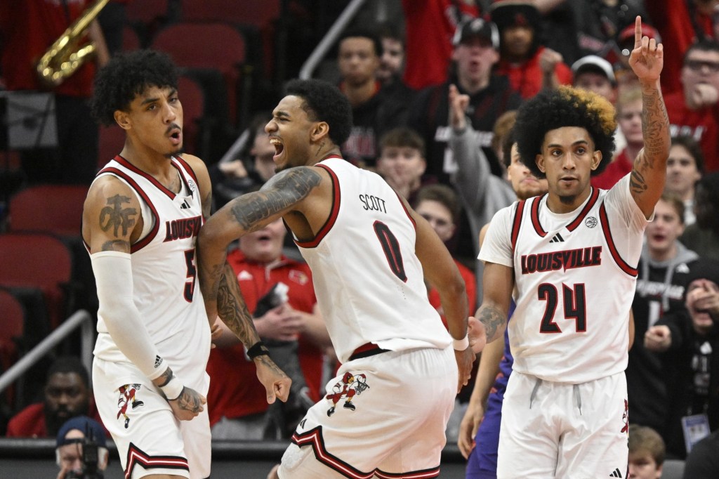 Jan 7, 2025; Louisville, Kentucky, USA; Louisville Cardinals forward James Scott (0) celebrates with guard Terrence Edwards Jr. (5) and guard Chucky Hepburn (24) during the second half against the Clemson Tigers at KFC Yum! Center. Louisville defeated Clemson 74-64.