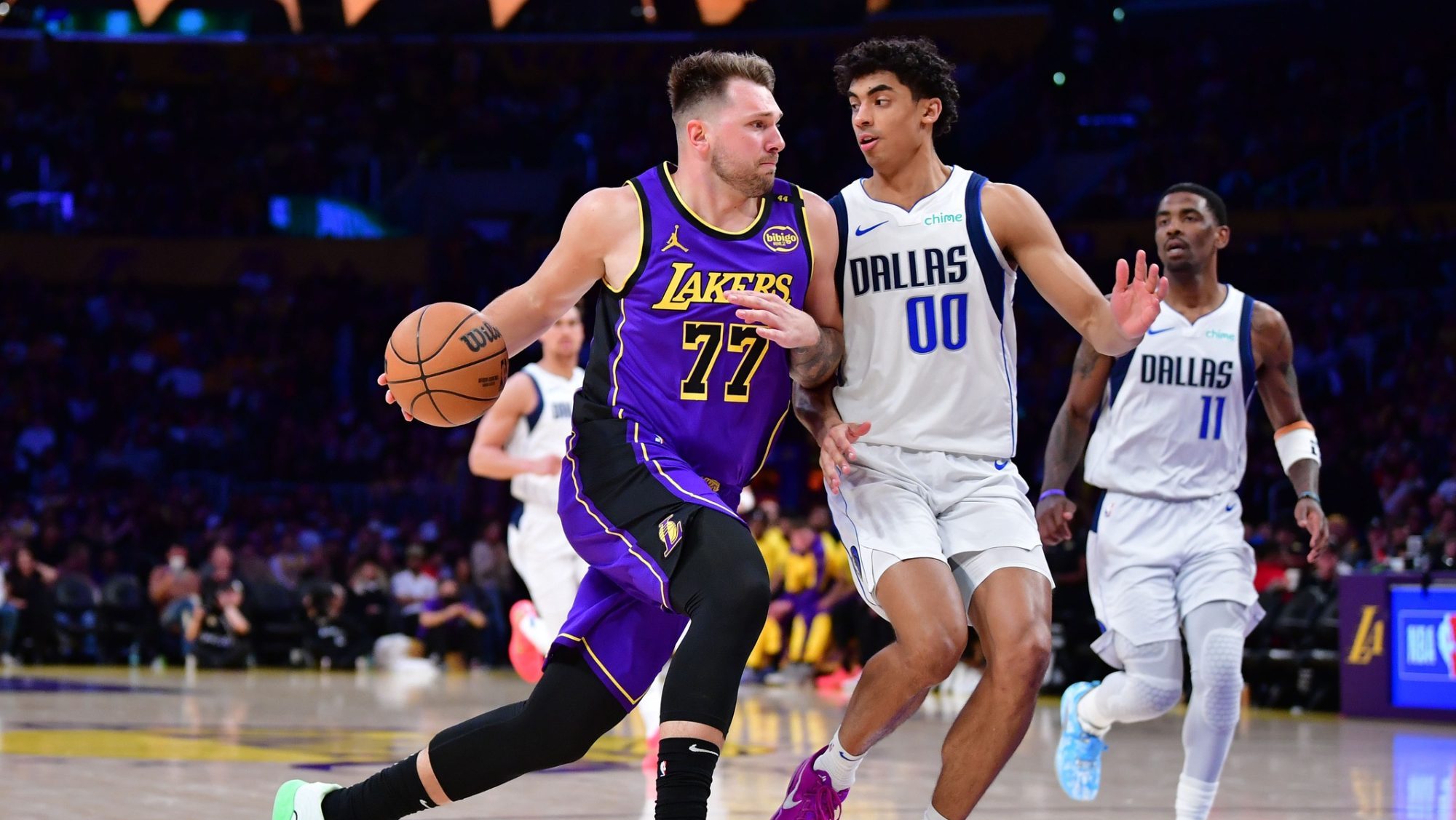 Feb 25, 2025; Los Angeles, California, USA; Los Angeles Lakers guard Luka Doncic (77) dribbles the ball Dallas Mavericks guard Max Christie (00) during the second half at Crypto.com Arena.