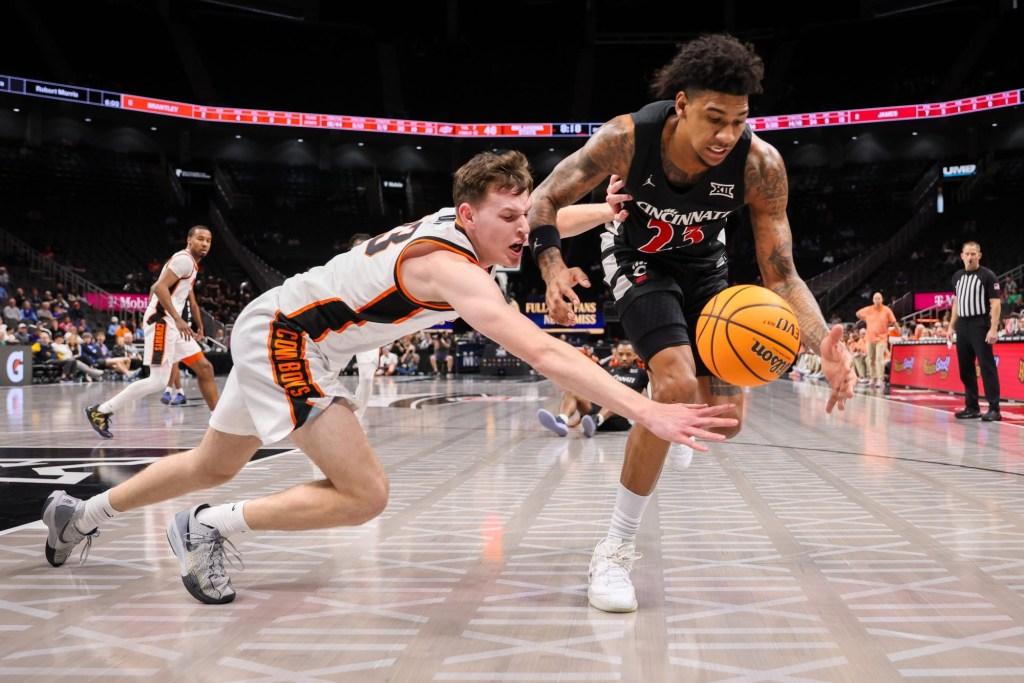 Mar 11, 2025; Kansas City, MO, USA; Cincinnati Bearcats forward Dillon Mitchell (23) and Oklahoma State Cowboys guard Connor Dow (13) go after a loose ball during the second half at T-Mobile Center.