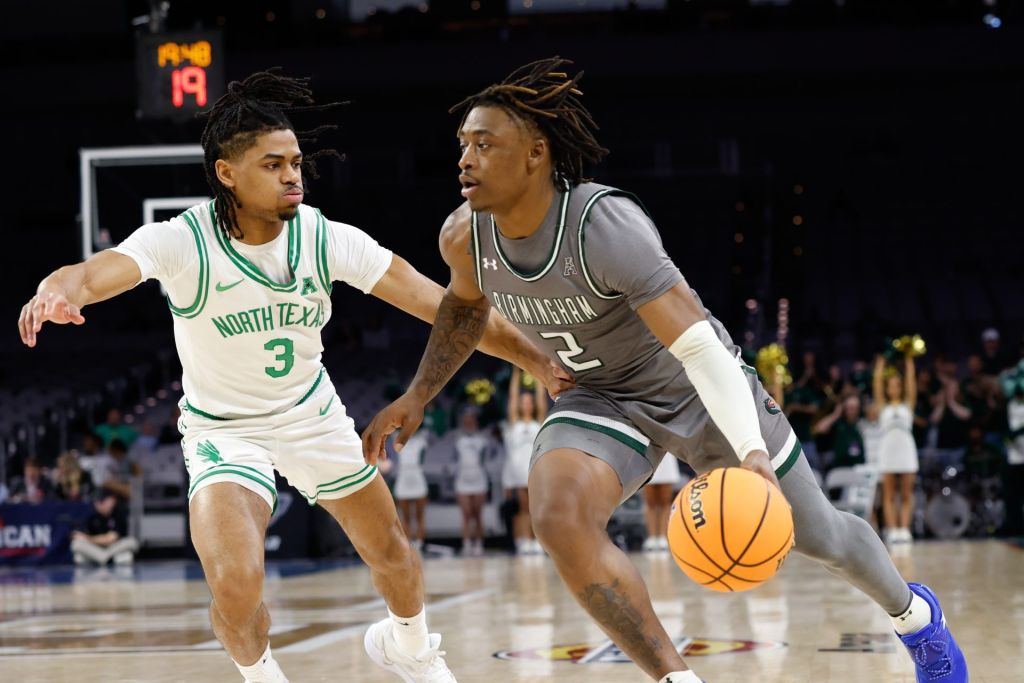 Mar 15, 2025; Fort Worth, TX, USA; UAB Blazers guard Ja'Borri McGhee (2) drives to the basket as North Texas Mean Green guard Jasper Floyd (3) defends during the first half at Dickies Arena.