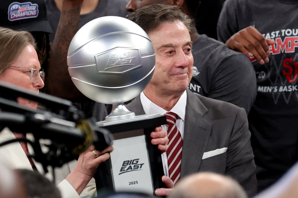 Mar 15, 2025; New York, NY, USA; Big East Conference commissioner Val Ackerman (left) hands the championship trophy to St. John's Red Storm head coach Rick Pitino after St. John's defeated the Creighton Bluejays to win the Big East Tournament at Madison Square Garden.